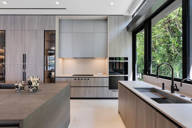 kitchen with a sink, cooktop, and modern cabinets