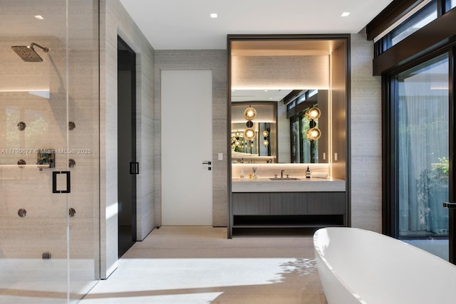 full bathroom featuring vanity, a freestanding tub, a shower stall, and wood finished floors
