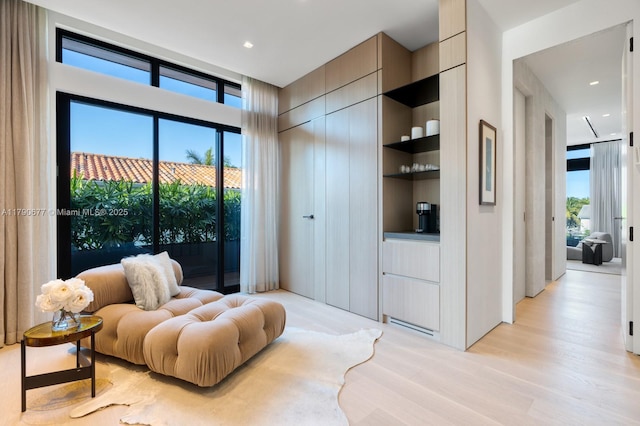 living area featuring recessed lighting, built in features, and light wood-style floors