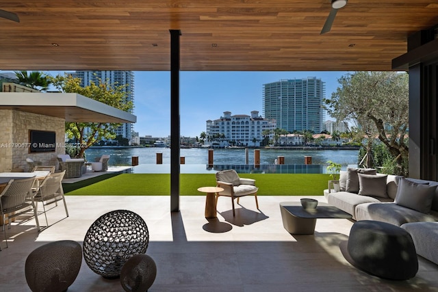view of patio / terrace with a ceiling fan, a water view, and an outdoor living space