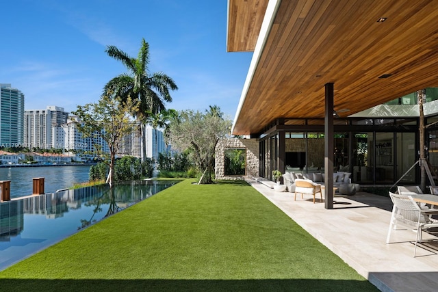 view of yard with a city view, a patio, outdoor lounge area, and a water view