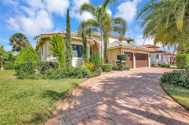 3260 SW 189th Ave, Miramar, FL 33029 - mediterranean / spanish house with a tiled roof, decorative driveway, a front lawn, an attached garage, and stucco siding