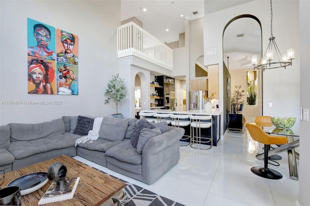 3260 SW 189th Ave, Miramar, FL 33029 - living area with light tile patterned flooring, an inviting chandelier, arched walkways, a towering ceiling, and visible vents