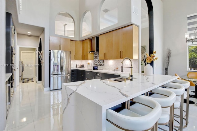 3260 SW 189th Ave, Miramar, FL 33029 - kitchen with decorative backsplash, a peninsula, stainless steel fridge with ice dispenser, light stone counters, and a sink