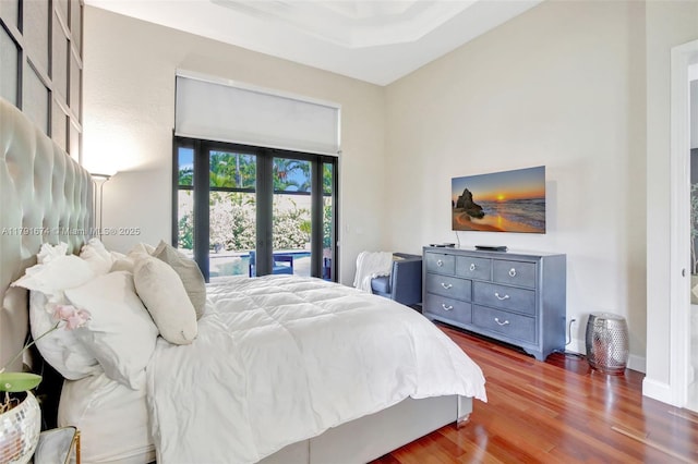 3260 SW 189th Ave, Miramar, FL 33029 - bedroom with baseboards, access to exterior, wood finished floors, and a tray ceiling