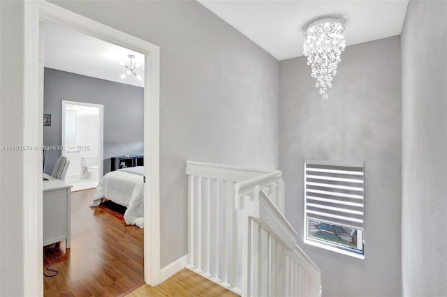 3260 SW 189th Ave, Miramar, FL 33029 - hallway with baseboards, wood finished floors, a chandelier, and an upstairs landing