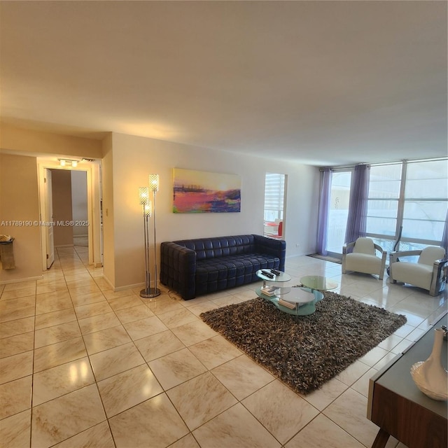 living area featuring light tile patterned flooring and baseboards