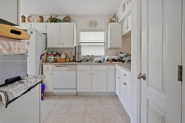 1754 Turtle Rock Dr, Lakeland, FL 33803 - kitchen with white appliances, light tile patterned floors, light countertops, a sink, and white cabinetry