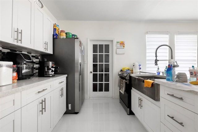 1922 NW 4th St, Miami, FL 33125 - kitchen with white cabinetry, stainless steel fridge, light stone counters, and a sink