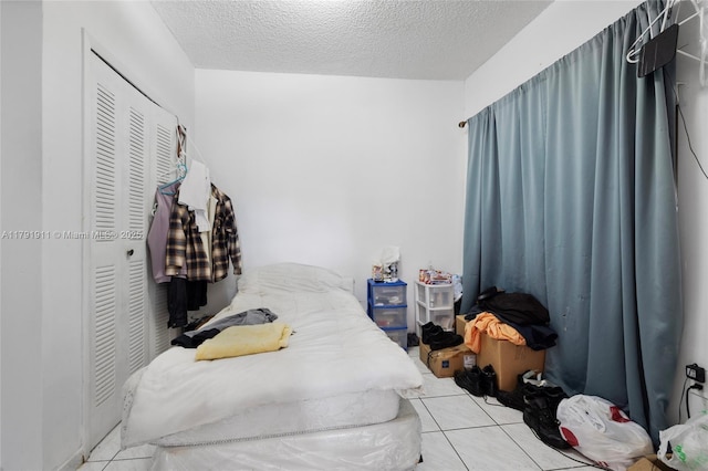 1922 NW 4th St, Miami, FL 33125 - bedroom with tile patterned floors, a closet, and a textured ceiling