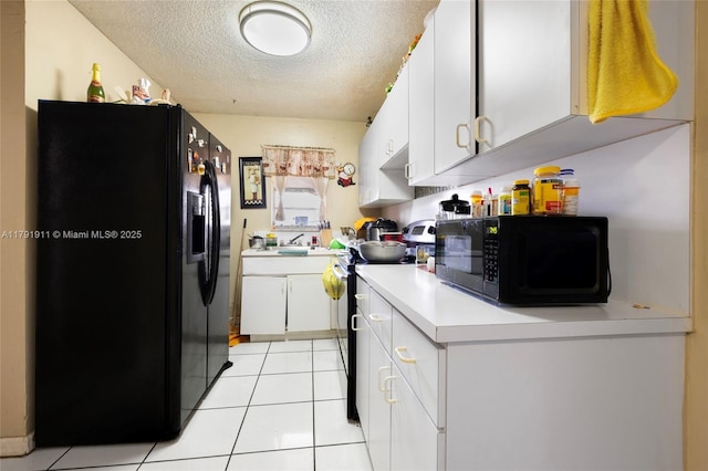 1922 NW 4th St, Miami, FL 33125 - kitchen featuring under cabinet range hood, a textured ceiling, black appliances, light countertops, and white cabinets