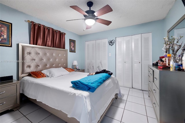 1922 NW 4th St, Miami, FL 33125 - bedroom featuring light tile patterned floors, ceiling fan, two closets, and a textured ceiling
