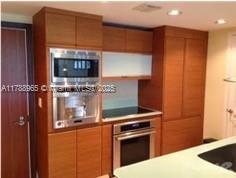 5875 Collins Ave Unit 1006, Miami Beach, FL 33140 - kitchen featuring appliances with stainless steel finishes, brown cabinets, recessed lighting, and light countertops