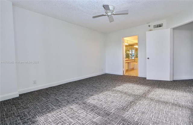 carpeted spare room featuring a textured ceiling, visible vents, ceiling fan, and baseboards