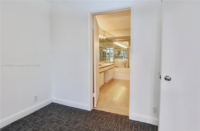 hallway with an inviting chandelier and carpet flooring