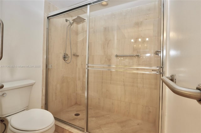 bathroom featuring toilet and a stall shower