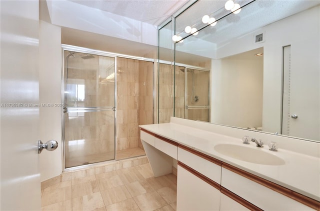 bathroom featuring visible vents, a shower stall, and vanity