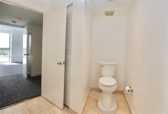 bathroom with toilet, tile patterned flooring, and baseboards