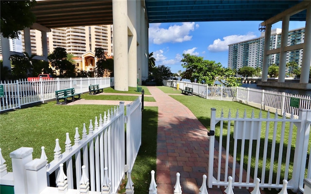 view of community featuring fence and a yard