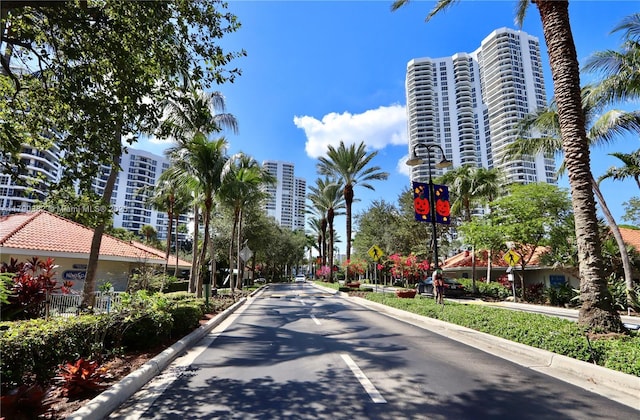 view of street with curbs, street lighting, a view of city, and traffic signs