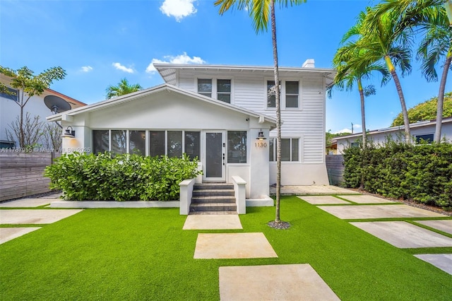view of front of house featuring fence, a chimney, a front yard, and entry steps