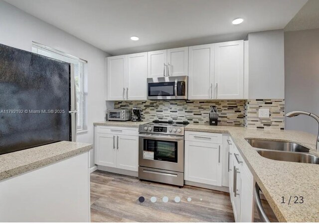 9880 Marina Blvd Unit 1516, Boca Raton, FL 33428 - kitchen with a sink, tasteful backsplash, white cabinets, and stainless steel appliances