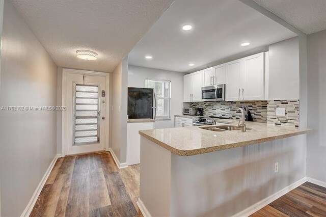 9880 Marina Blvd Unit 1516, Boca Raton, FL 33428 - kitchen featuring a sink, appliances with stainless steel finishes, wood finished floors, and a peninsula