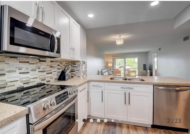 9880 Marina Blvd Unit 1516, Boca Raton, FL 33428 - kitchen featuring visible vents, white cabinetry, a sink, stainless steel appliances, and light wood-style flooring