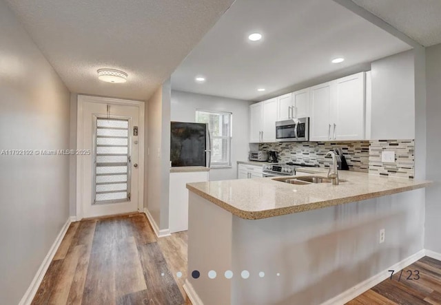 9880 Marina Blvd Unit 1516, Boca Raton, FL 33428 - kitchen with appliances with stainless steel finishes, a sink, a peninsula, baseboards, and tasteful backsplash