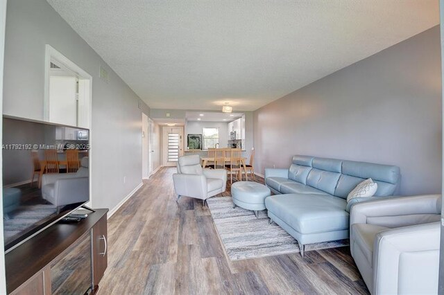 9880 Marina Blvd Unit 1516, Boca Raton, FL 33428 - living room featuring baseboards and wood finished floors