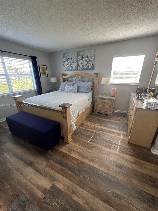 9880 Marina Blvd Unit 1516, Boca Raton, FL 33428 - bedroom featuring a textured ceiling, dark wood-style floors, and baseboards