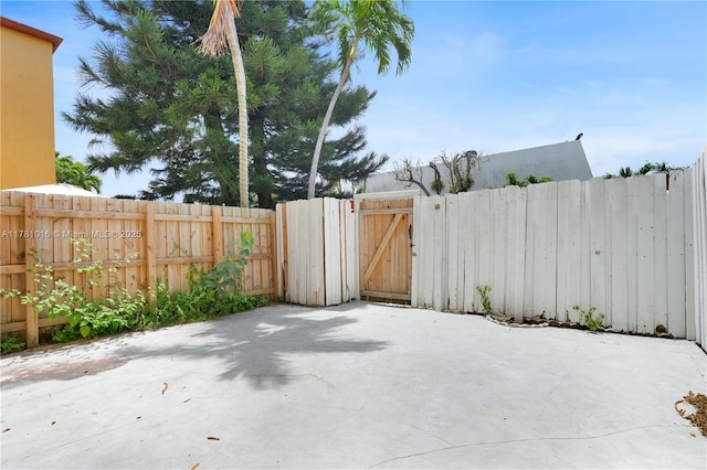 view of patio featuring fence and a gate