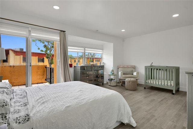 bedroom with baseboards, recessed lighting, wood finished floors, and access to outside