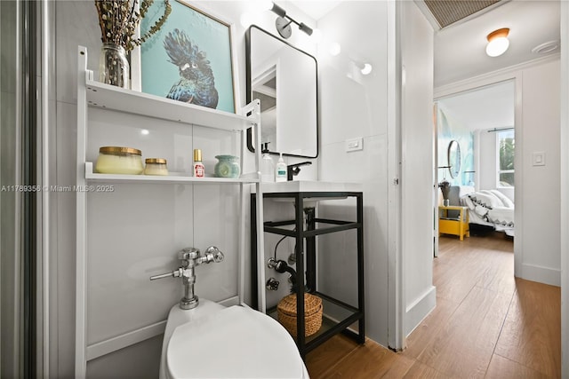 bathroom with wood finished floors, visible vents, and baseboards