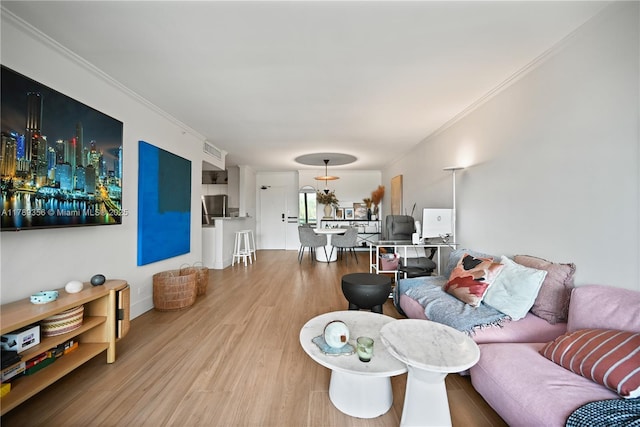 living area featuring visible vents, wood finished floors, and ornamental molding