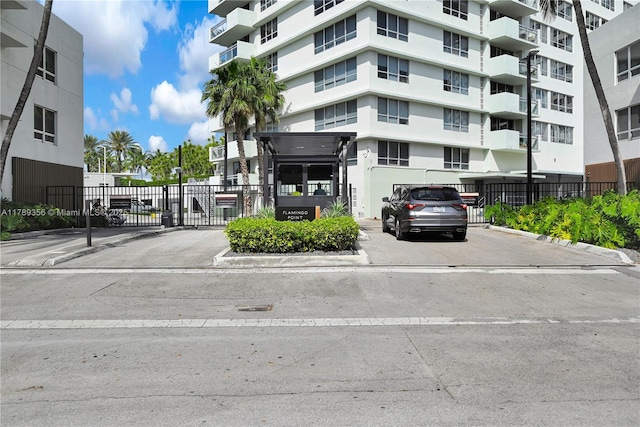 view of property with fence and uncovered parking