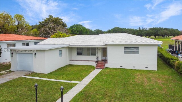 1025 Hunting Lodge Dr, Miami Springs, FL 33166 - view of front of home with a front yard, stucco siding, driveway, and a tile roof