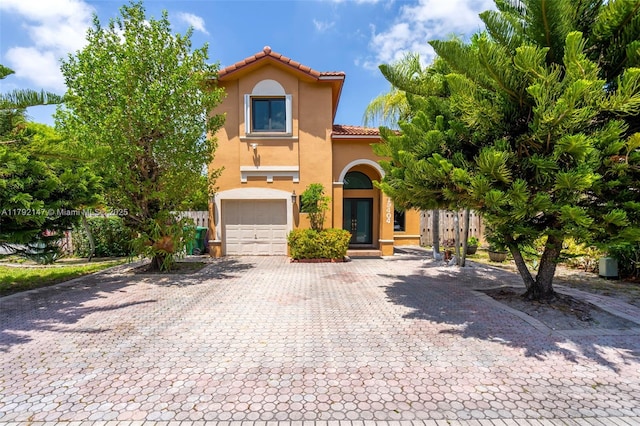19404 NW 79th Ct, Hialeah, FL 33015 - mediterranean / spanish-style house featuring stucco siding, a garage, decorative driveway, and a tiled roof