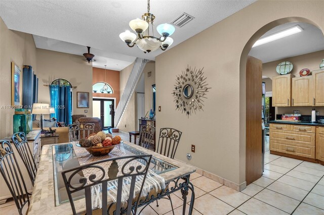 19404 NW 79th Ct, Hialeah, FL 33015 - dining room with arched walkways, a chandelier, light tile patterned floors, a textured ceiling, and baseboards