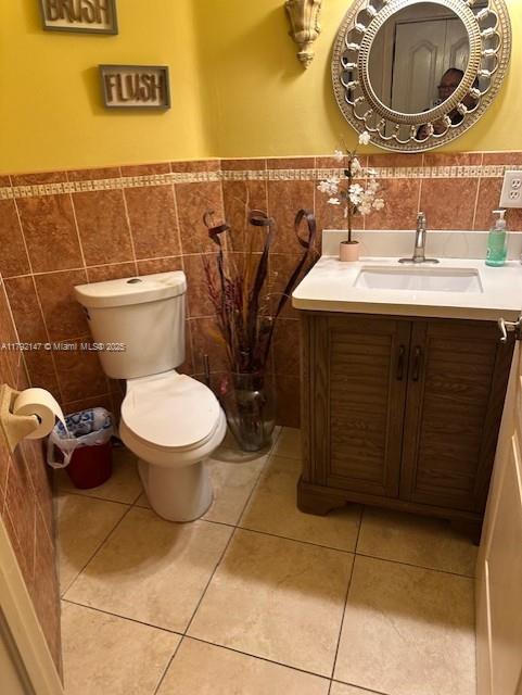 19404 NW 79th Ct, Hialeah, FL 33015 - bathroom featuring tile walls, wainscoting, tile patterned floors, toilet, and vanity