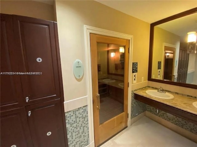 bathroom featuring tile patterned flooring, double vanity, and a sink