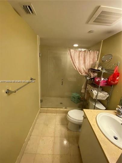 full bathroom featuring toilet, visible vents, a shower stall, and vanity