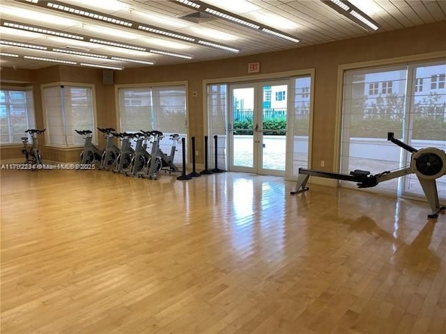 exercise room featuring wood finished floors and french doors