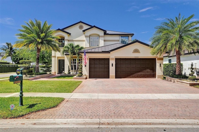 19323 SW 55th St, Miramar, FL 33029 - view of front of home featuring a standing seam roof, metal roof, decorative driveway, an attached garage, and stucco siding
