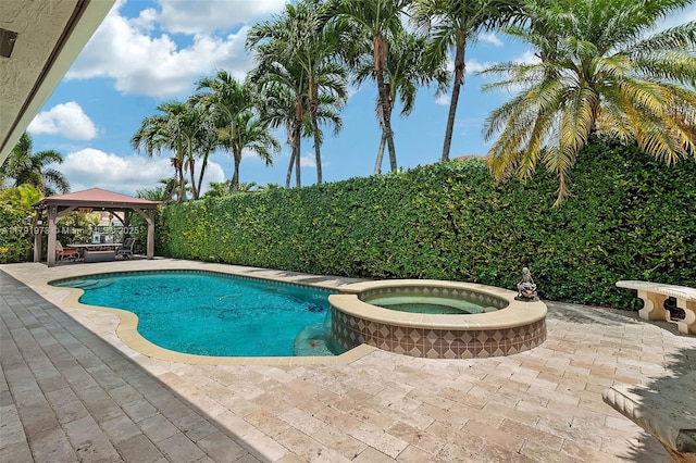 view of pool featuring a patio, a gazebo, and a pool with connected hot tub