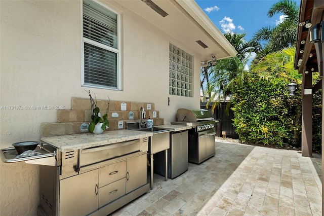 view of patio with fence, area for grilling, and a sink