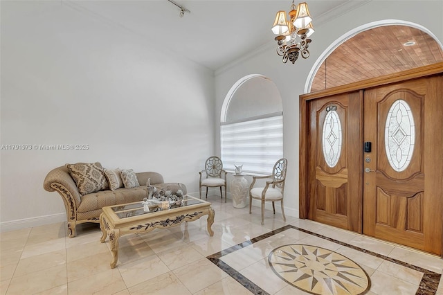 entryway with a chandelier, baseboards, ornamental molding, and a wealth of natural light