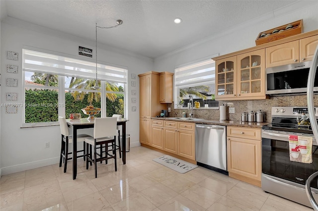 kitchen with glass insert cabinets, light brown cabinetry, stainless steel appliances, backsplash, and a sink