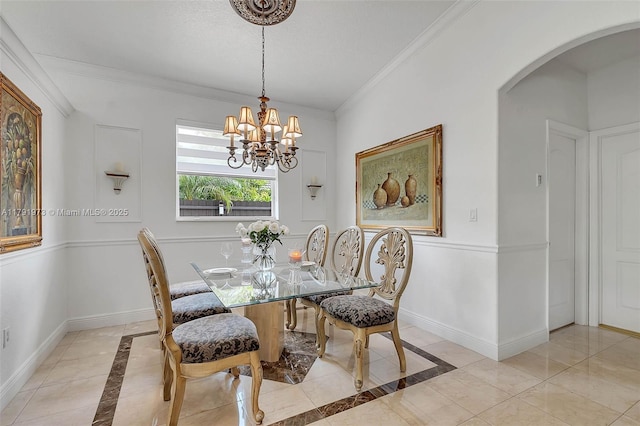 dining room with ornamental molding, arched walkways, a chandelier, and baseboards