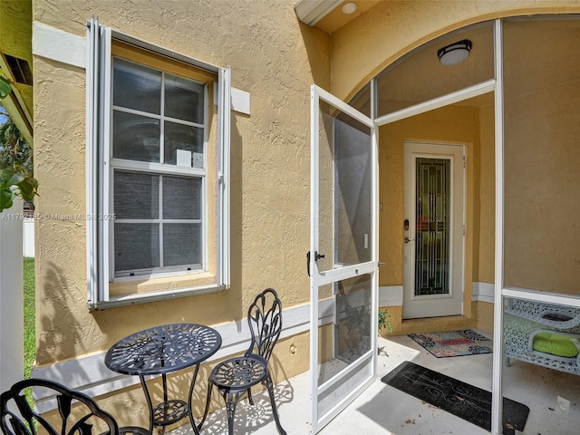 entrance to property featuring stucco siding